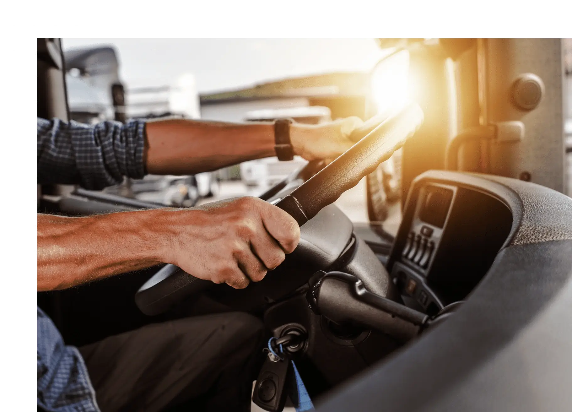 Person gripping a car steering wheel while driving.